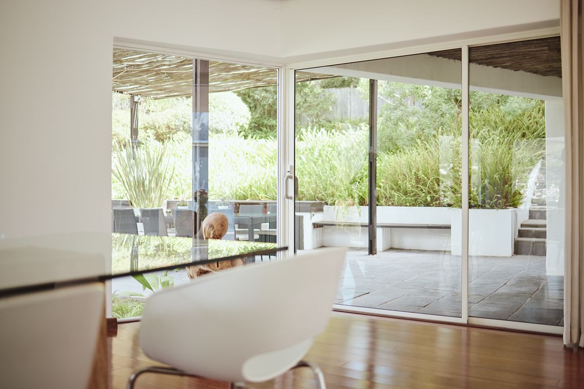 Aluminum sliding glass doors connecting a dining area to an outdoor patio with clean, easy-to-maintain frames