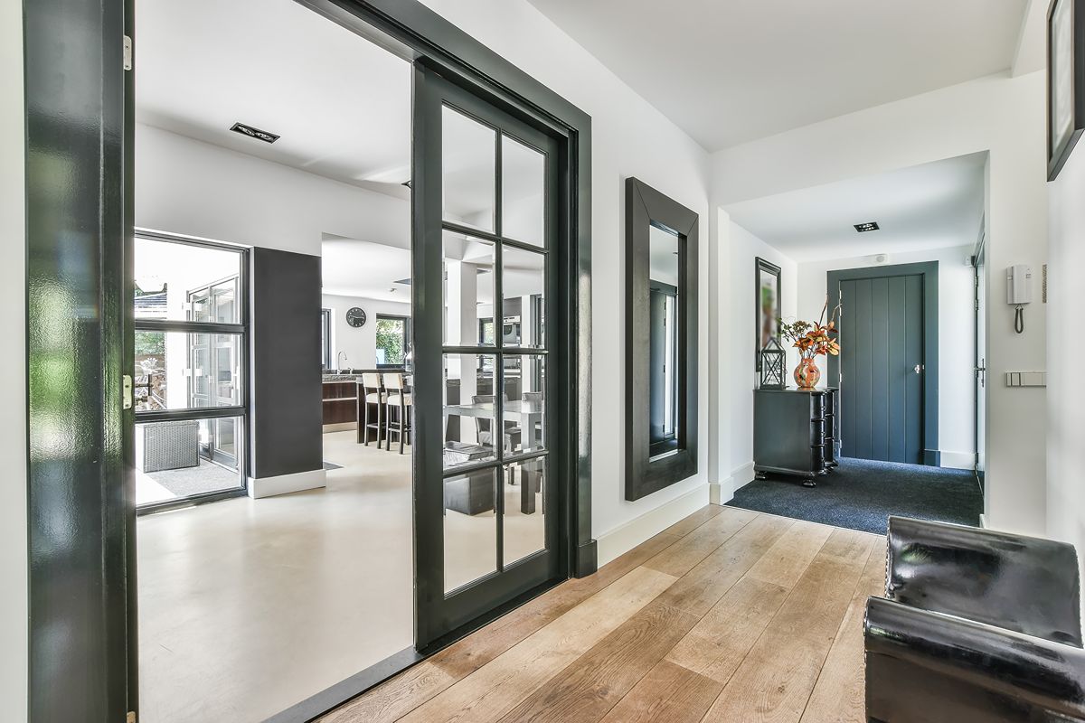 Interior hallway with aluminum-framed doors showing a polished, low-maintenance home design