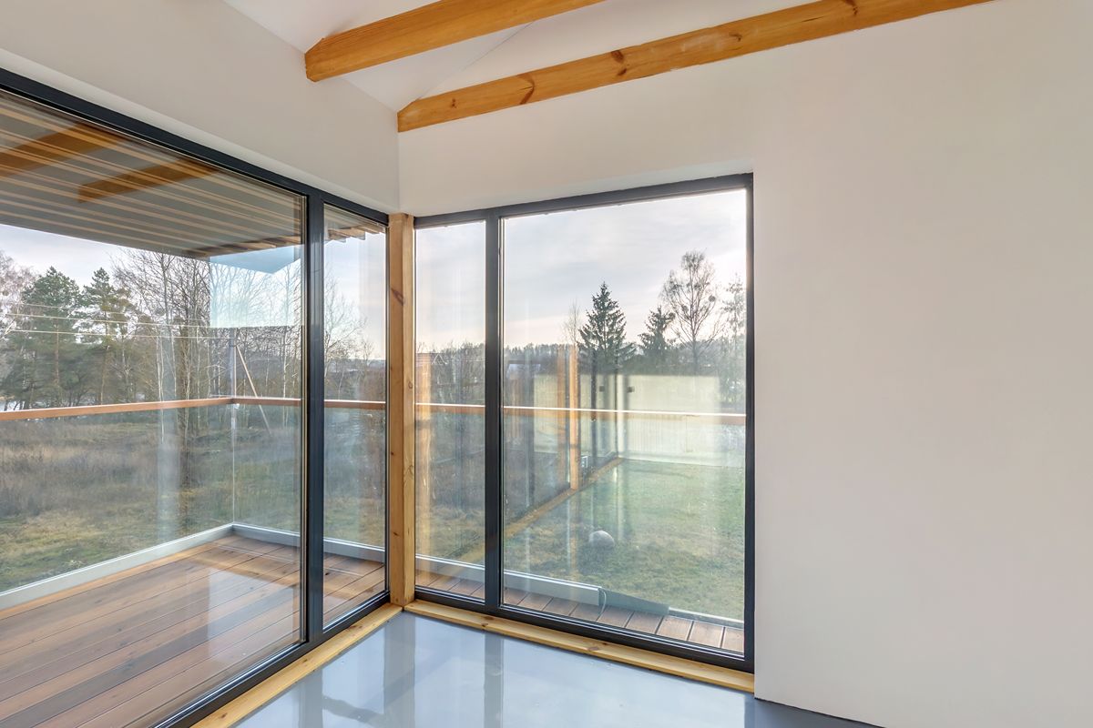 Corner sliding glass doors with slim dark frames in a bright modern home interior