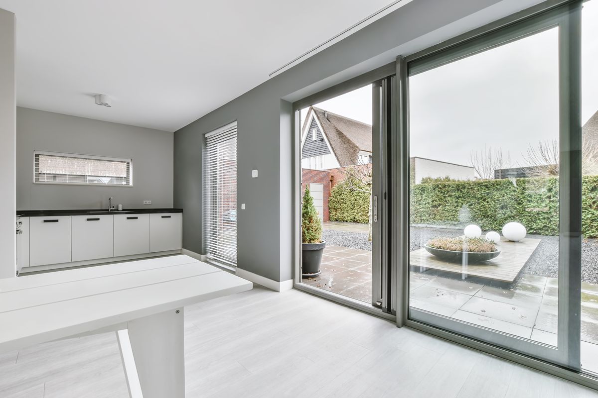 Modern kitchen with sliding glass doors opening to an outdoor patio and garden