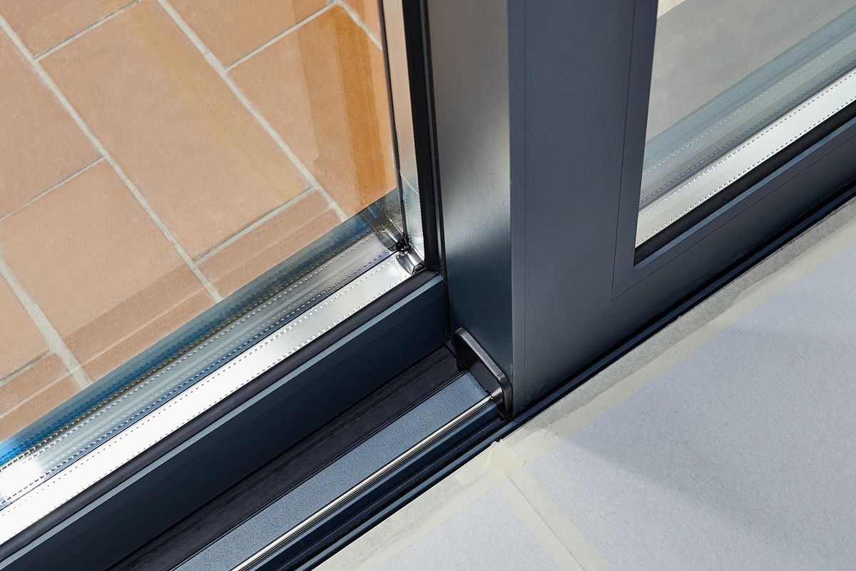 Close-up of an aluminum sliding door frame, track, and glass panel working together for smooth operation